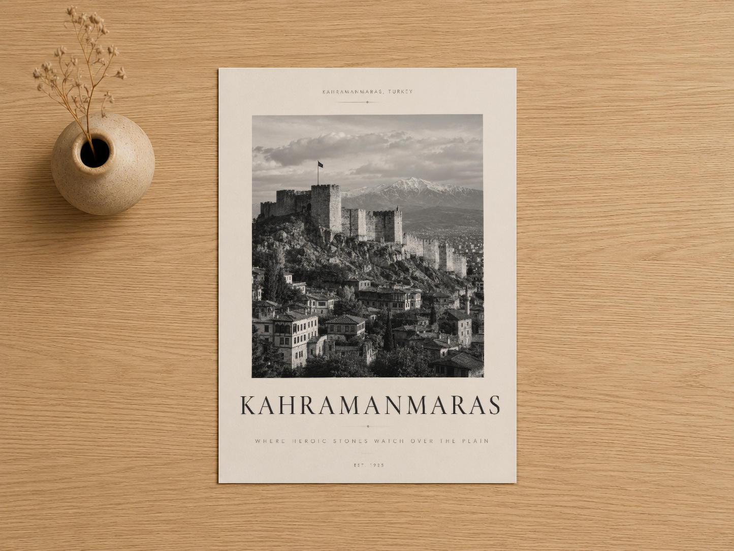 Kahramanmaraş'ın tarihî silüetini gösteren siyah beyaz sanat baskısı, hastalıklı ahşap zemin üzerinde.