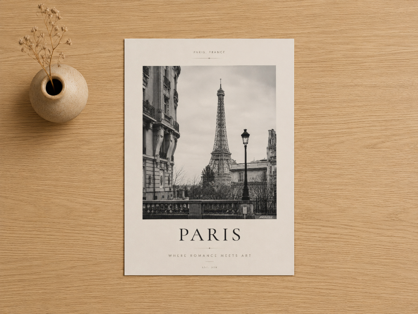 Paris temalı siyah beyaz tablosu, krema rengi vazo ile ahşap zemin üzerinde gösterilen sanat baskısı detayı.