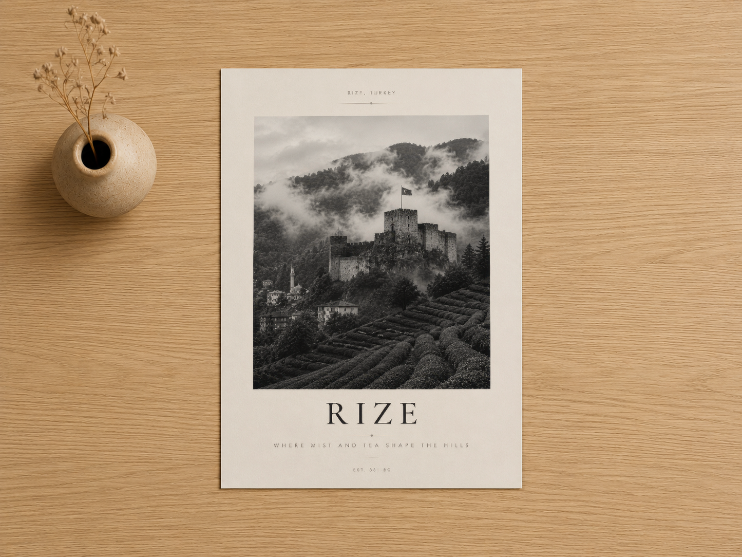 Rize kalesinin bulutlu gökyüzü altında fotoğraflandığı sanat baskısı, sade beyaz çerçevede, ahşap masa üzerinde sergileniyor.