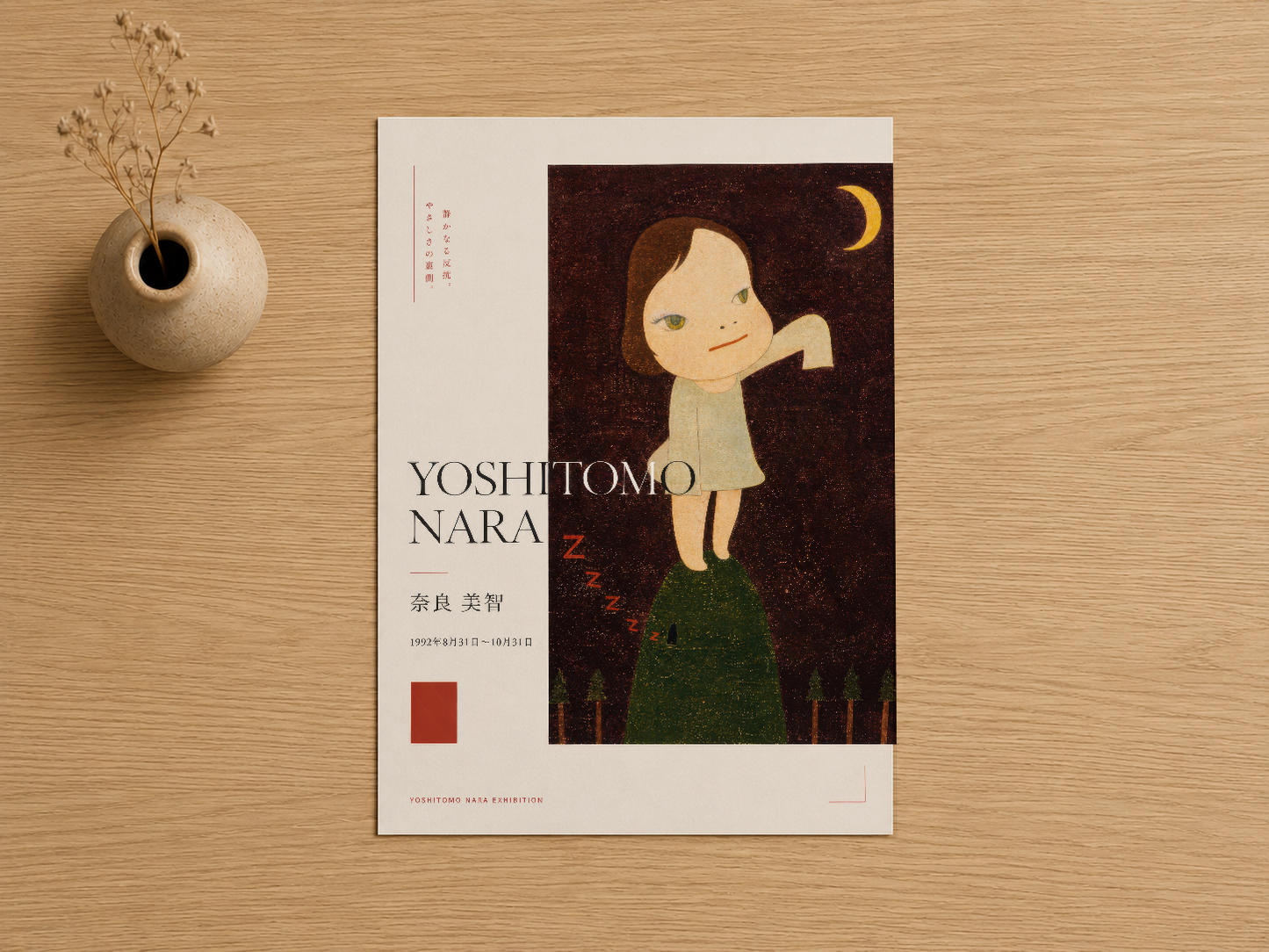 Yoshitomo Nara sergisi posteri, ahşap masa üzerinde seramik vazo yanında düz görünümde, detay açısından çekilmiş.