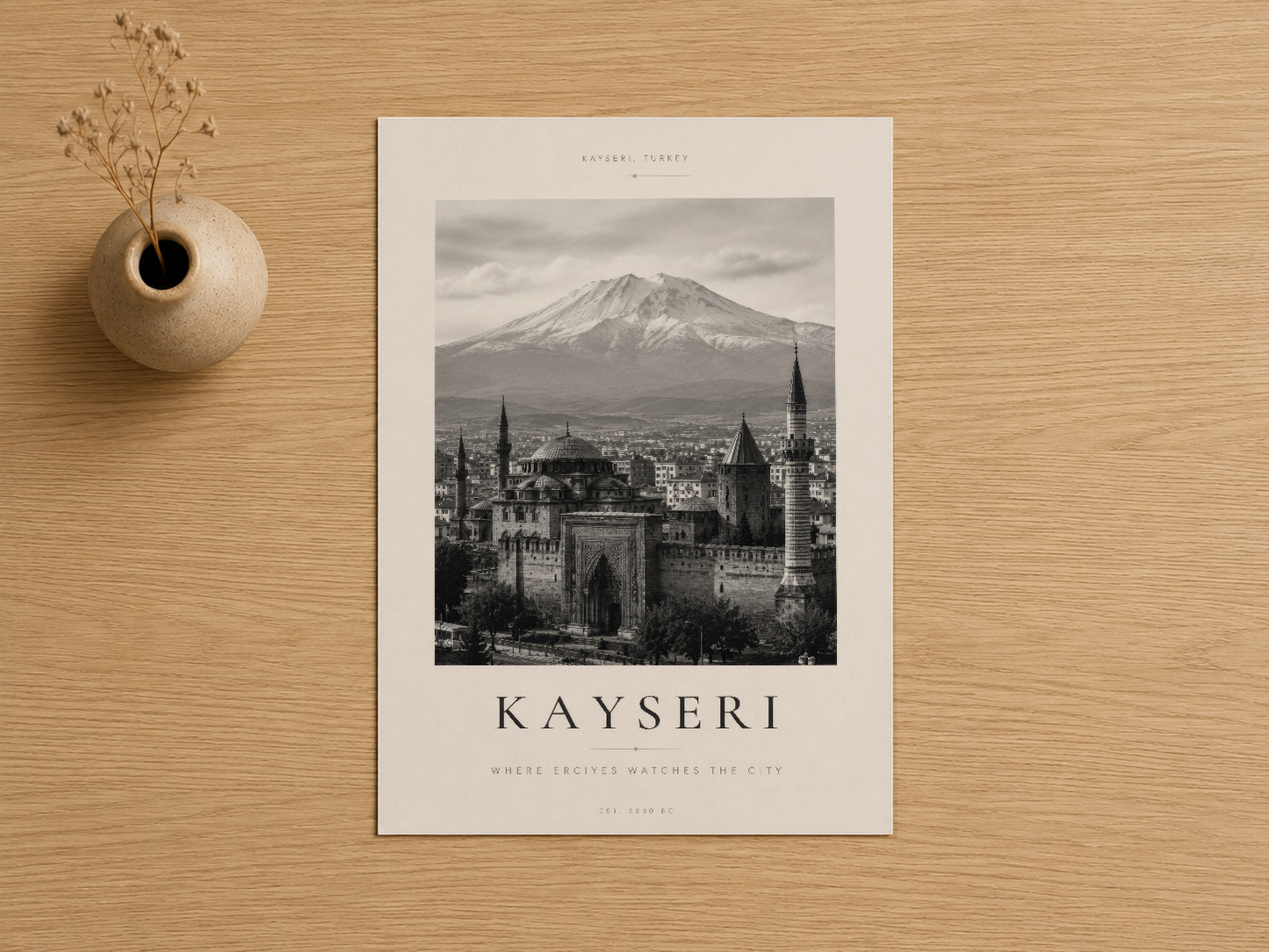 Kayseri şehri ve dağ silüetinin yer aldığı zarif siyah-beyaz sanat tablosu, ahşap zeminde sunuluyor.