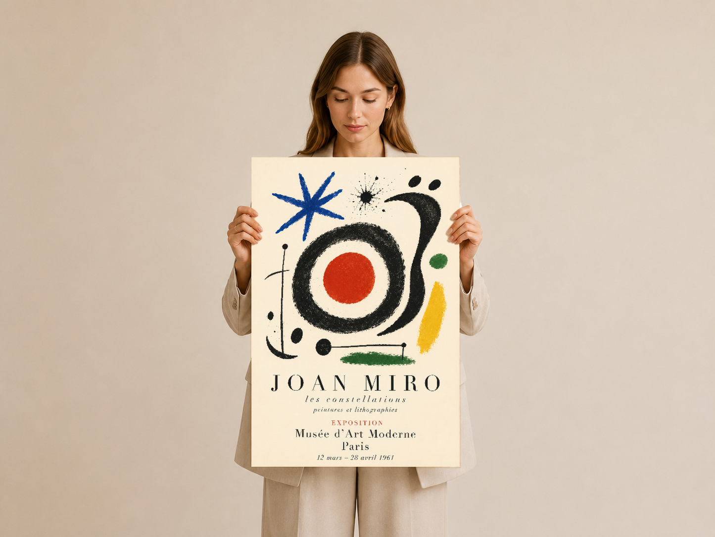 Soyut modernist tasarımlı Joan Miró duvar tablosunu elden tutar halde gösteren ürün görseli.
