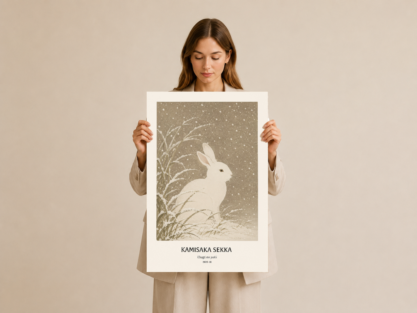 Kadın tarafından tutulan, tavşan desenli sanat tablosu, klasik poster formatında.