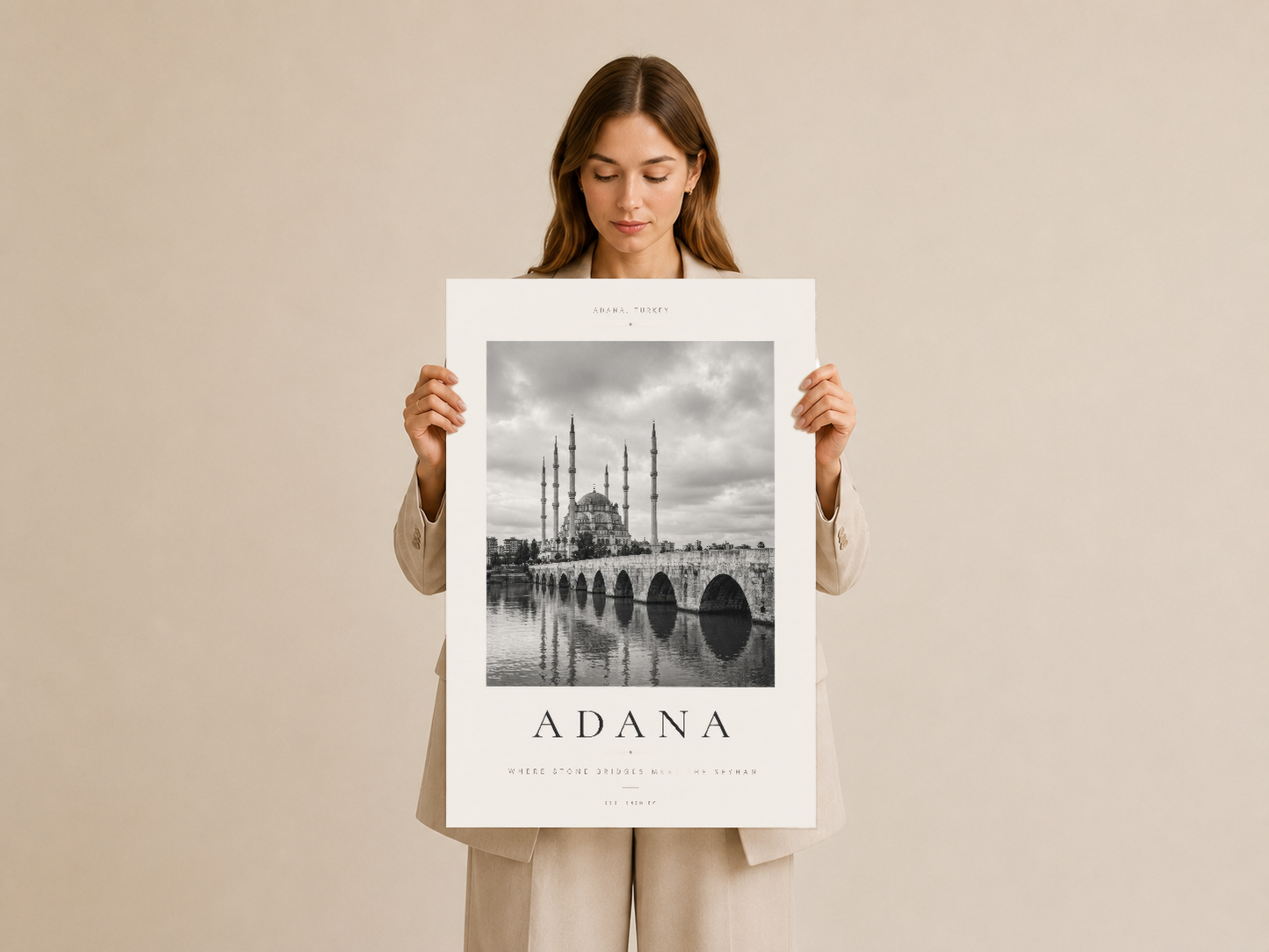 Adana duvar posteri, beyaz çerçevesi ve tarihi mimari görüntüsü ile elinde tutulmuş durumda.