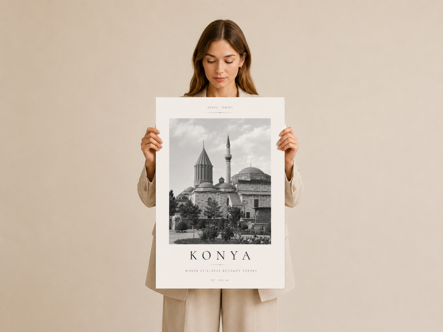 Konya Türkiye duvar tablosu, krem çerçeveli poster, kadın tarafından tutuluyor, minimalist tasarım.