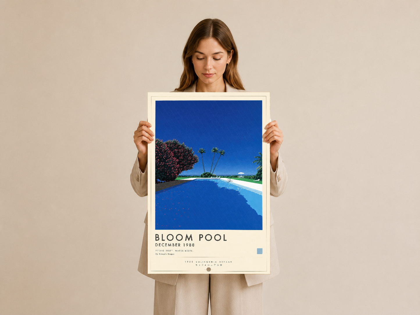 Bloom Pool tablosu elle tutulmuş halde, beyaz çerçeveli tasarımın canlı mavi göl detayı.