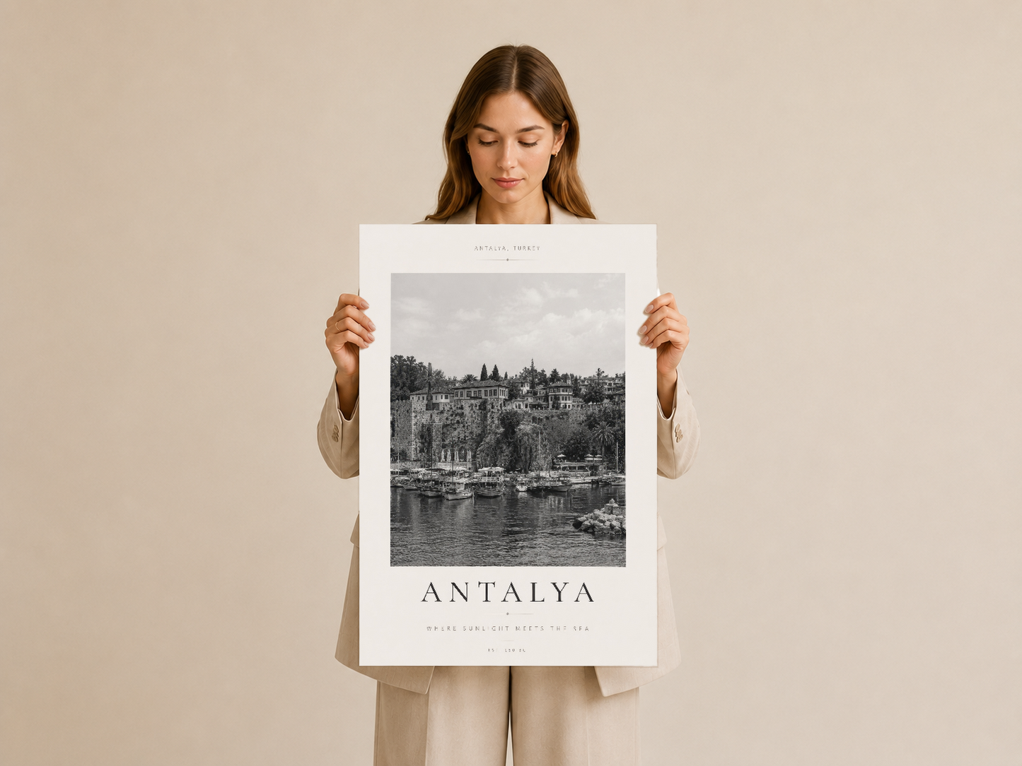 Antalya şehir panoramasını gösteren zarif tasarımlı poster, beyaz çerçeveli duvar sanatı olarak tutulmuş halde.