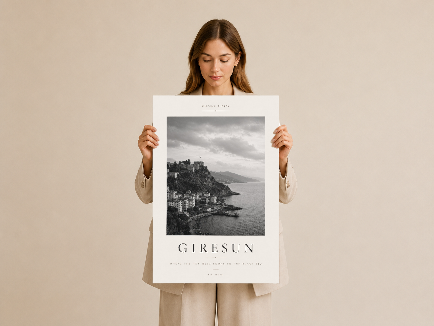 Giresun posteri, kadının elinde tuttuğu beyaz çerçeveli siyah beyaz kıyı ve dağ manzarası baskısı.