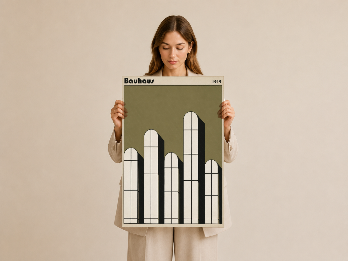 Bauhaus tarzı minimalist mimari tasarım posteri, krem tonunda ahşap çerçevede, elle tutuluyor.