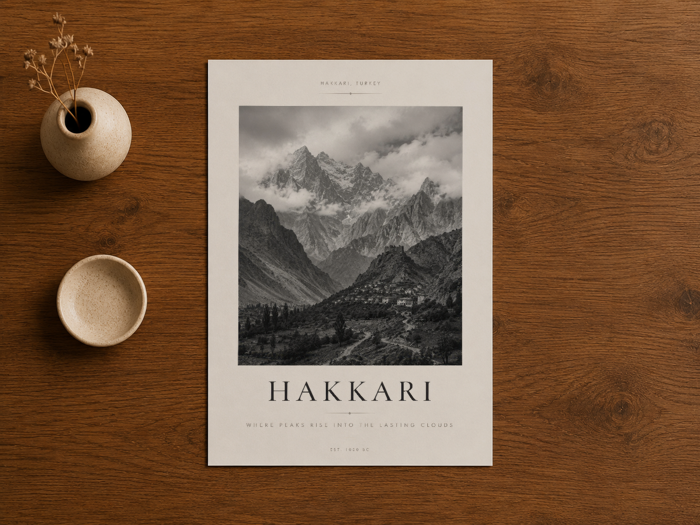 Hakkari Dağları posteri, ahşap masada dekoratif aksessuarlarla beraber sergilenen sanat eseri.