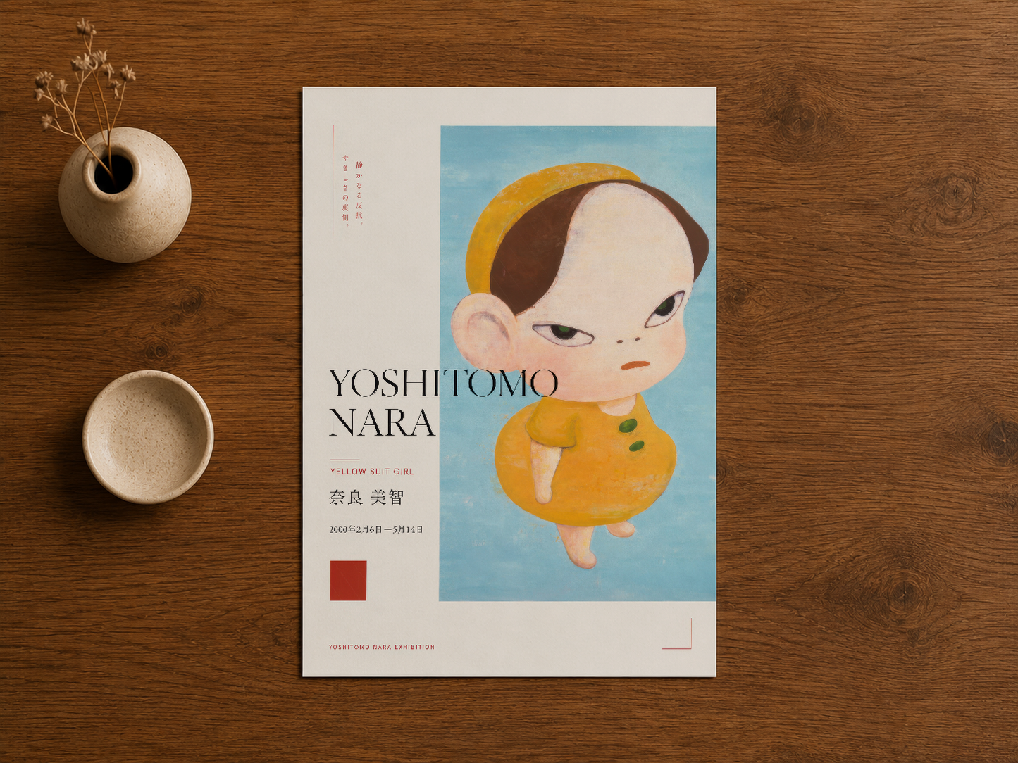 Yoshitomo Nara poster ahşap masa üzerinde, seramik dekorasyonlar ve doğal çiçeklerle birlikte.