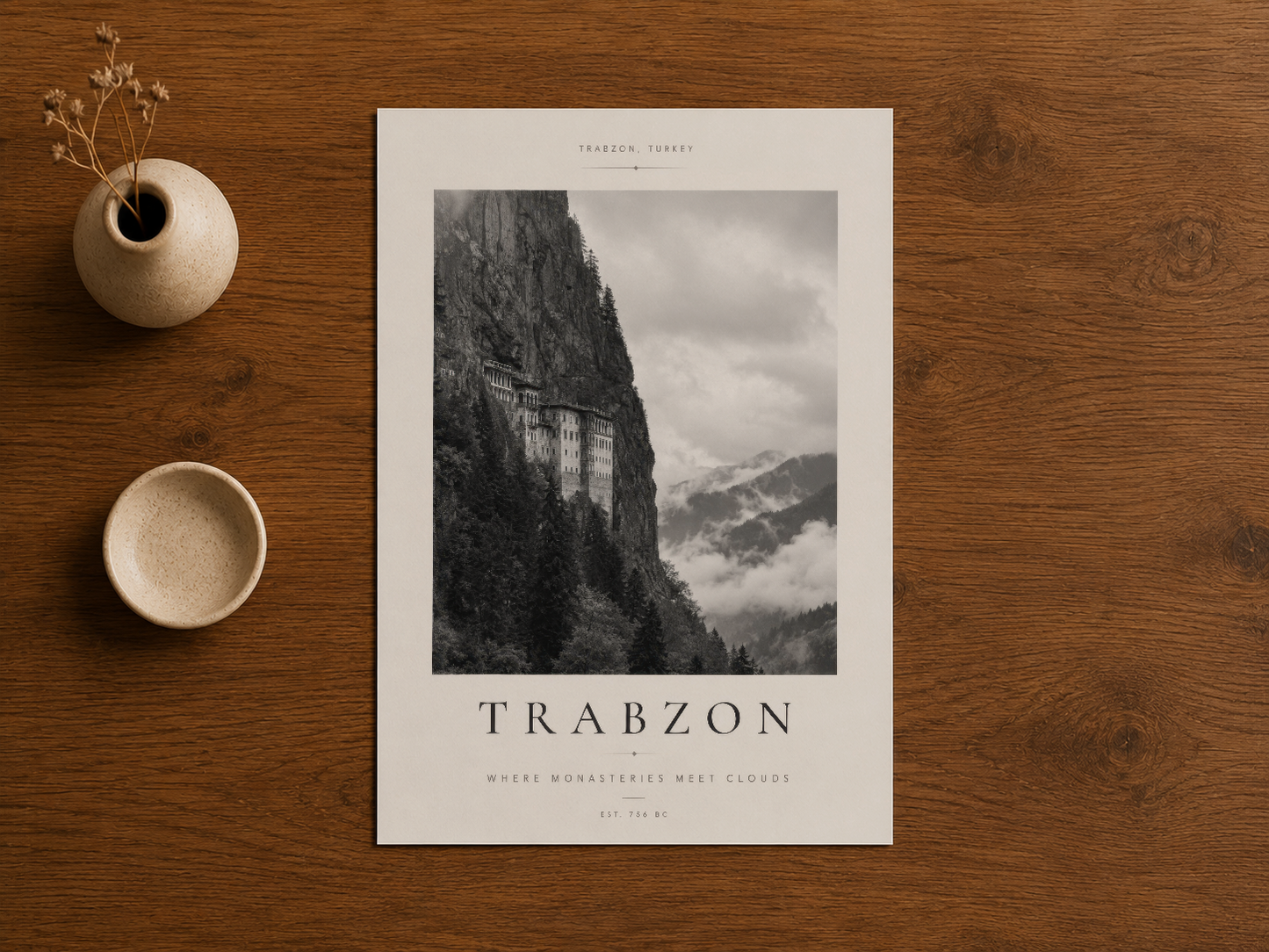 Ahşap masada Trabzon manastırı duvar sanatı, minimalist dekoratif aksesuarlarla.