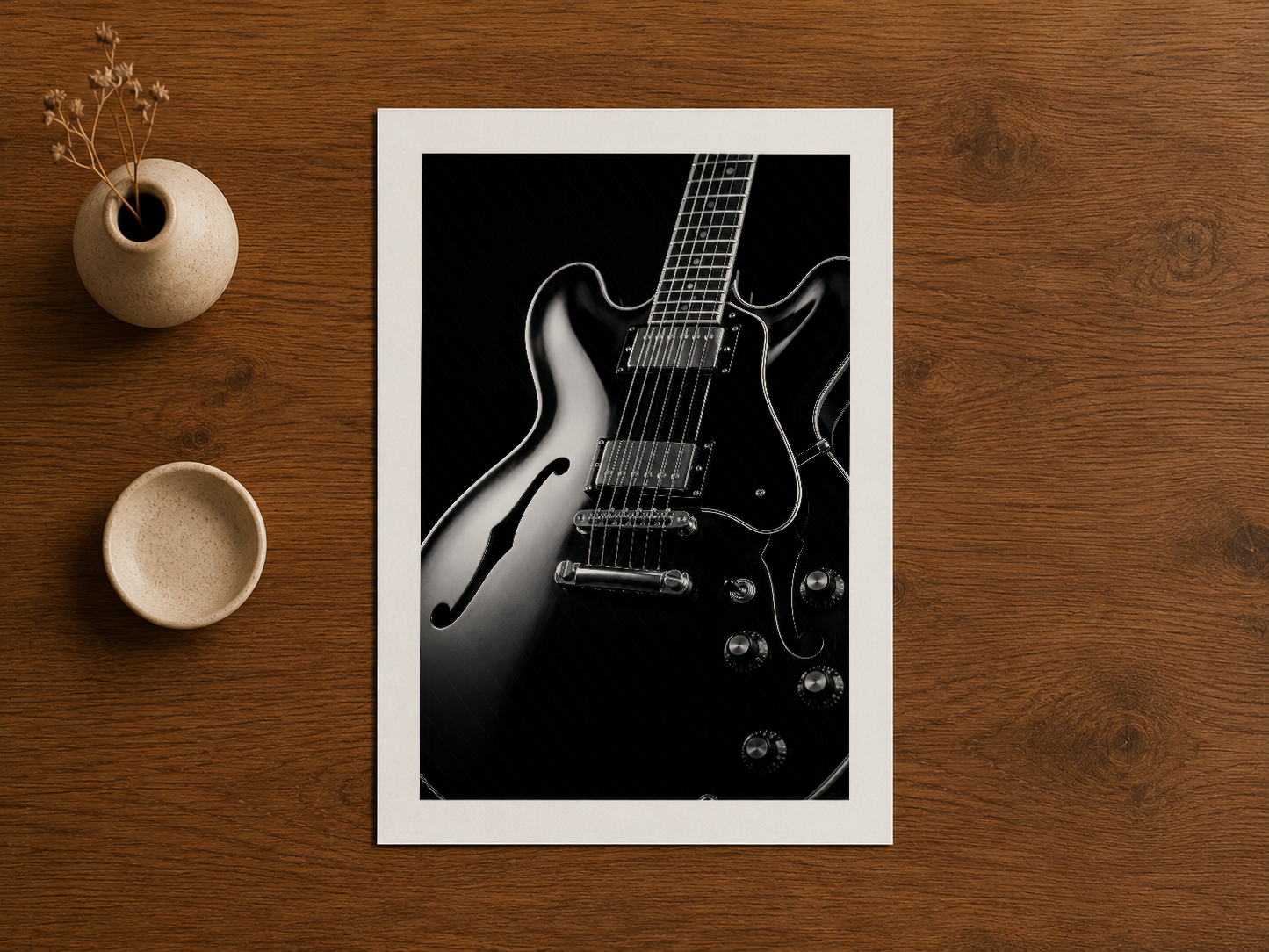 Ahşap masa üzerinde sergilenen gitar sanat eseri, doğal dekorasyon aksesuarlarıyla uyum sağlıyor.