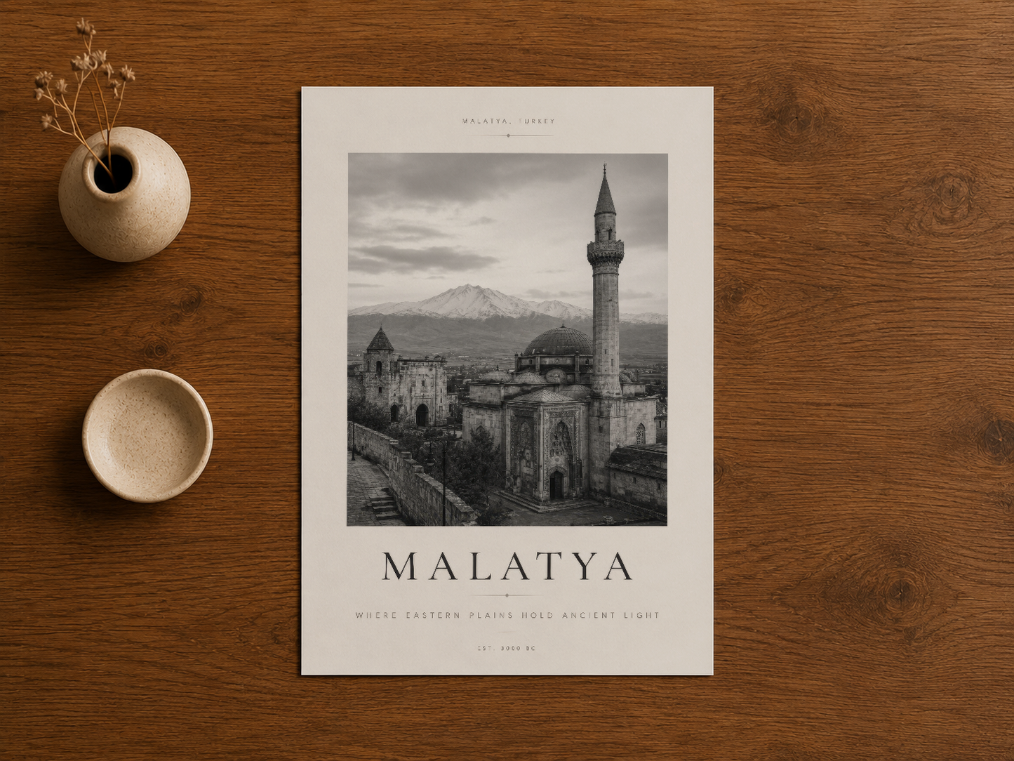Malatya şehir manzarası tablosu, ahşap masada yanında dekoratif seramik ürünlerle yatay yerleşim.
