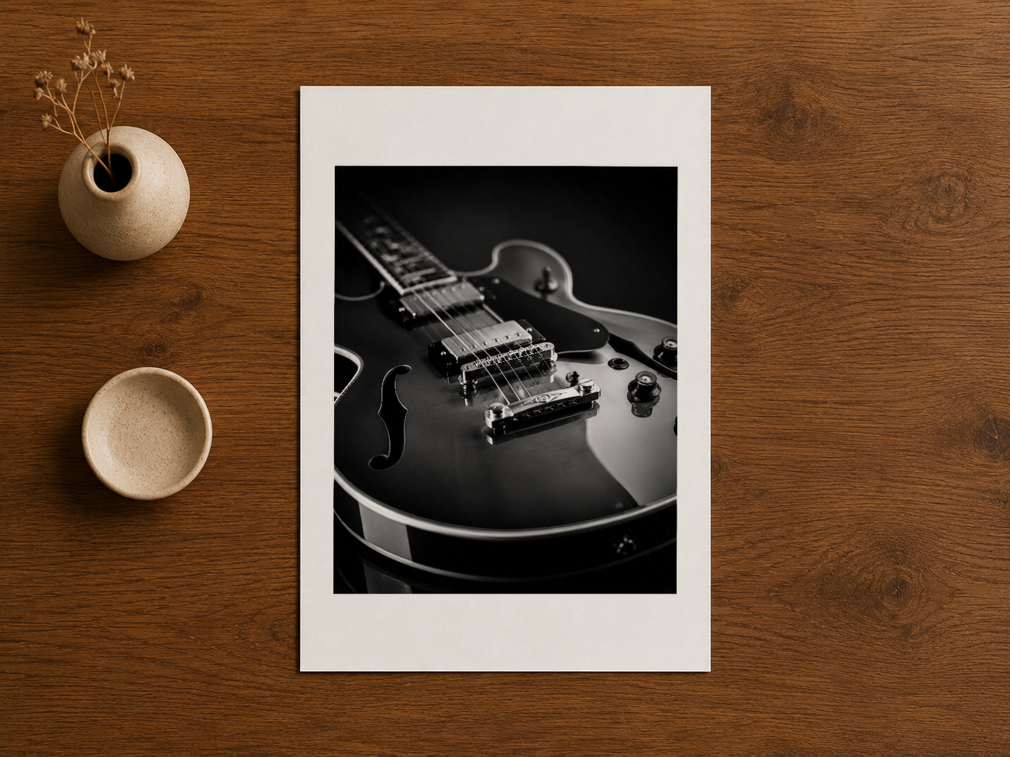 Gitar konulu minimalist tablo, ahşap çalışma masasında sanat malzemeleriyle sergileniyor.