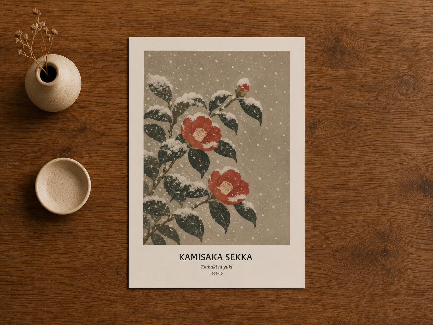 Kamisaka Sekka sanat baskısı ahşap masada sergilenen, yapraklar ve kızıl çiçekler ihtiva eden tasarım.