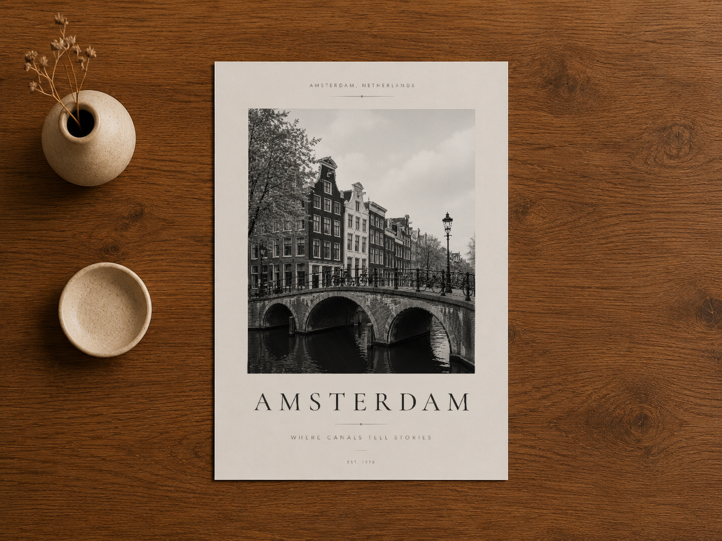 Amsterdam sanat baskısı, ahşap masa üzerinde pürüzsüz tasarımı ve entelektüel atmosferiyle sergilenmekte.