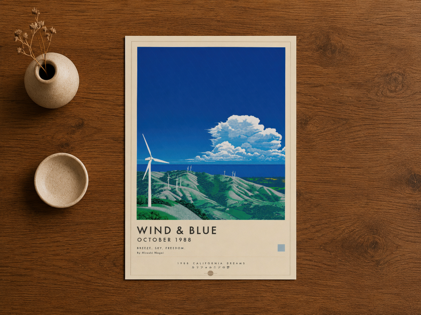 Wind & Blue rüzgar enerjisi temalı poster, ahşap masa üstünde çerçeveli sanatsal baskı.
