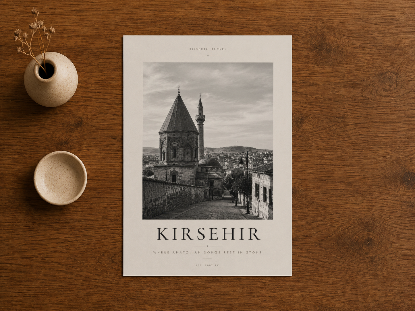Kırşehir mimarisinin siyah-beyaz tasarım posterleri ahşap zeminde doğal dekora uyumlu.