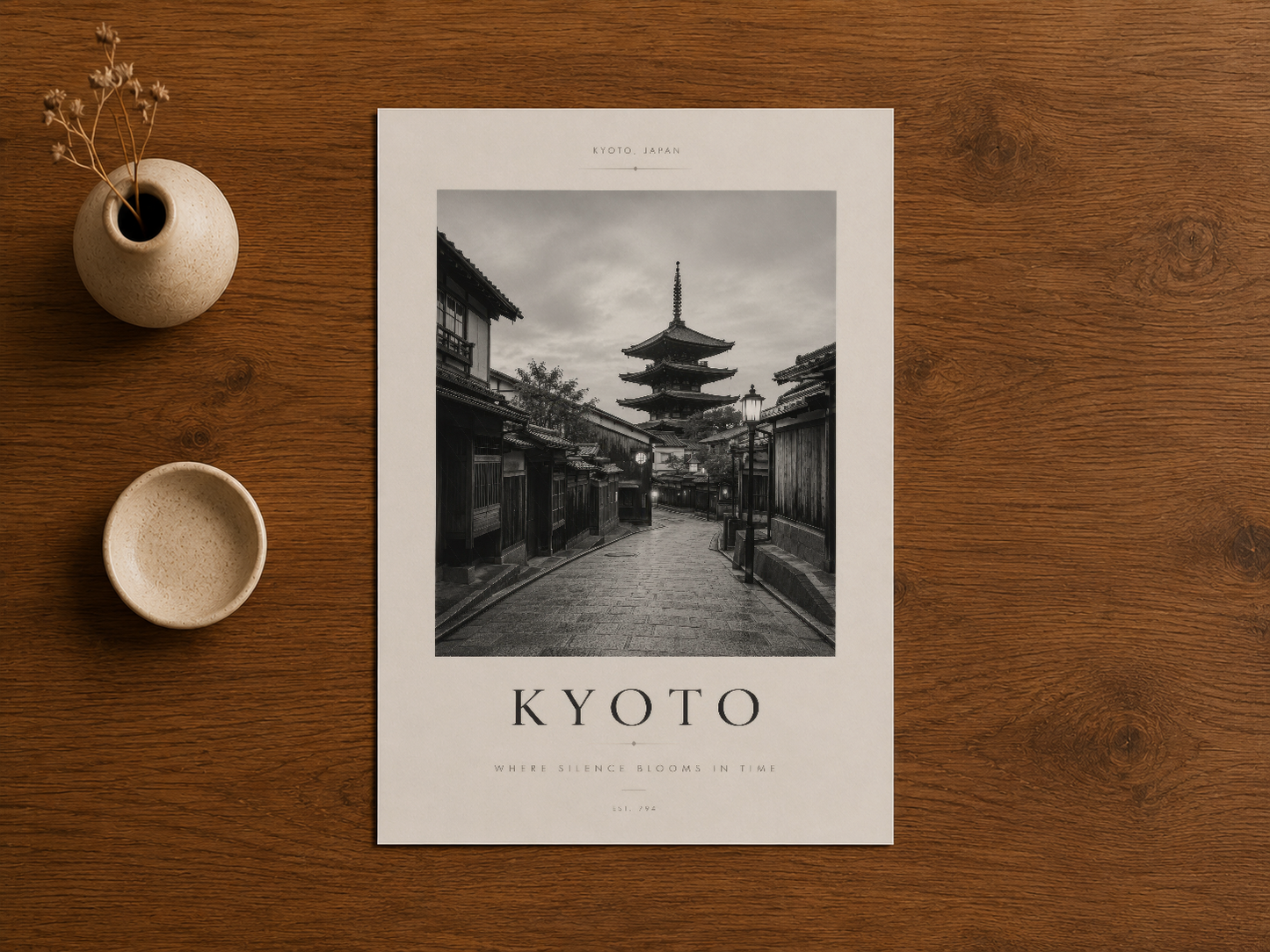 Kyoto cadde manzarasının siyah-beyaz baskısı, ahşap masa üzerinde seramik aksesuarlarla birlikte.