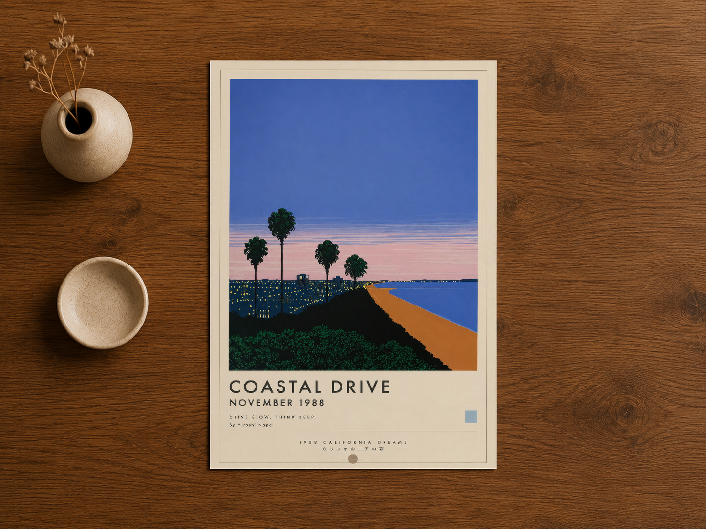Seramik vazo ve fincan yanında ahşap çerçevedeki Coastal Drive sanat tablosu, minimalist stil.