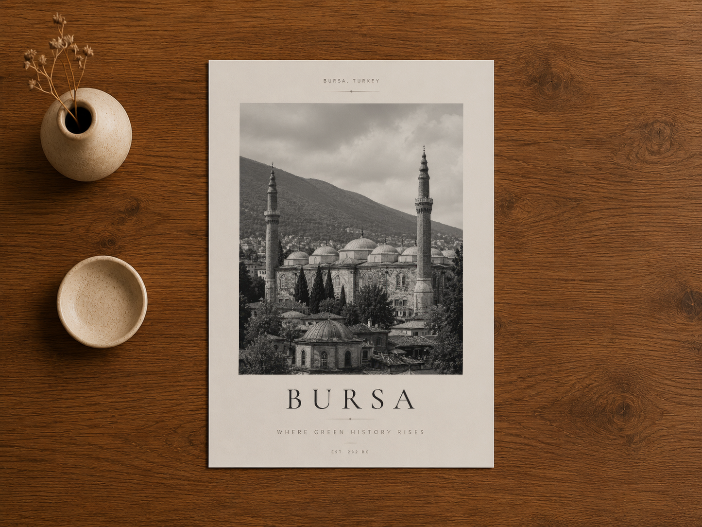 Bursa travel poster, doğal ahşap masada seramik dekorasyonlarla birlikte stil içinde konumlandırılmış.