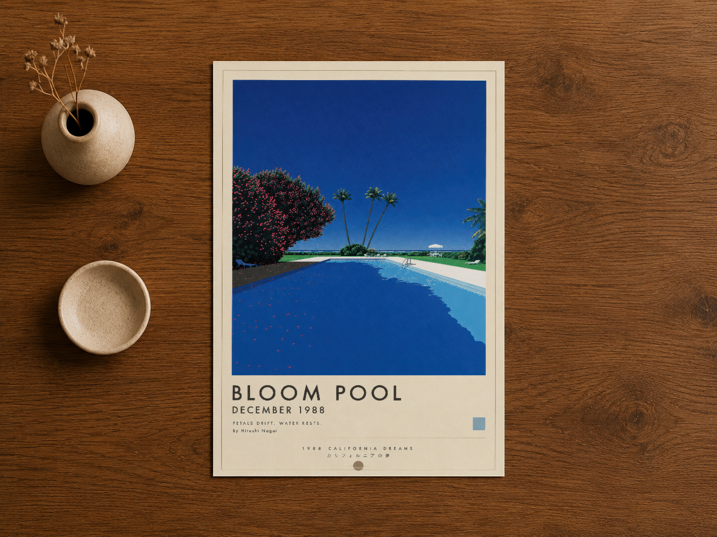 Bloom Pool posterinin minimalist çerçeveyle ahşap zemin üzerinde dekoratif ürünlerle birlikte gösterimi.