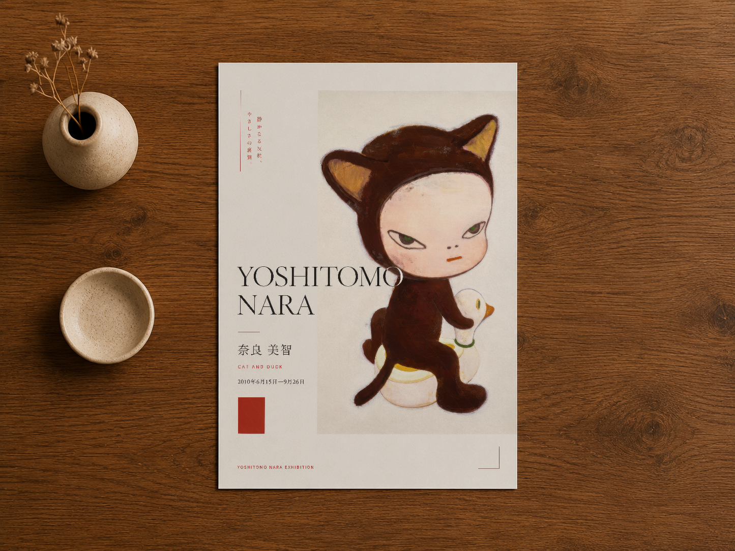Kahverengi ahşap zeminle sergilenen Yoshitomo Nara posteri, minimalist estetik ve natürel sanat sunumu.