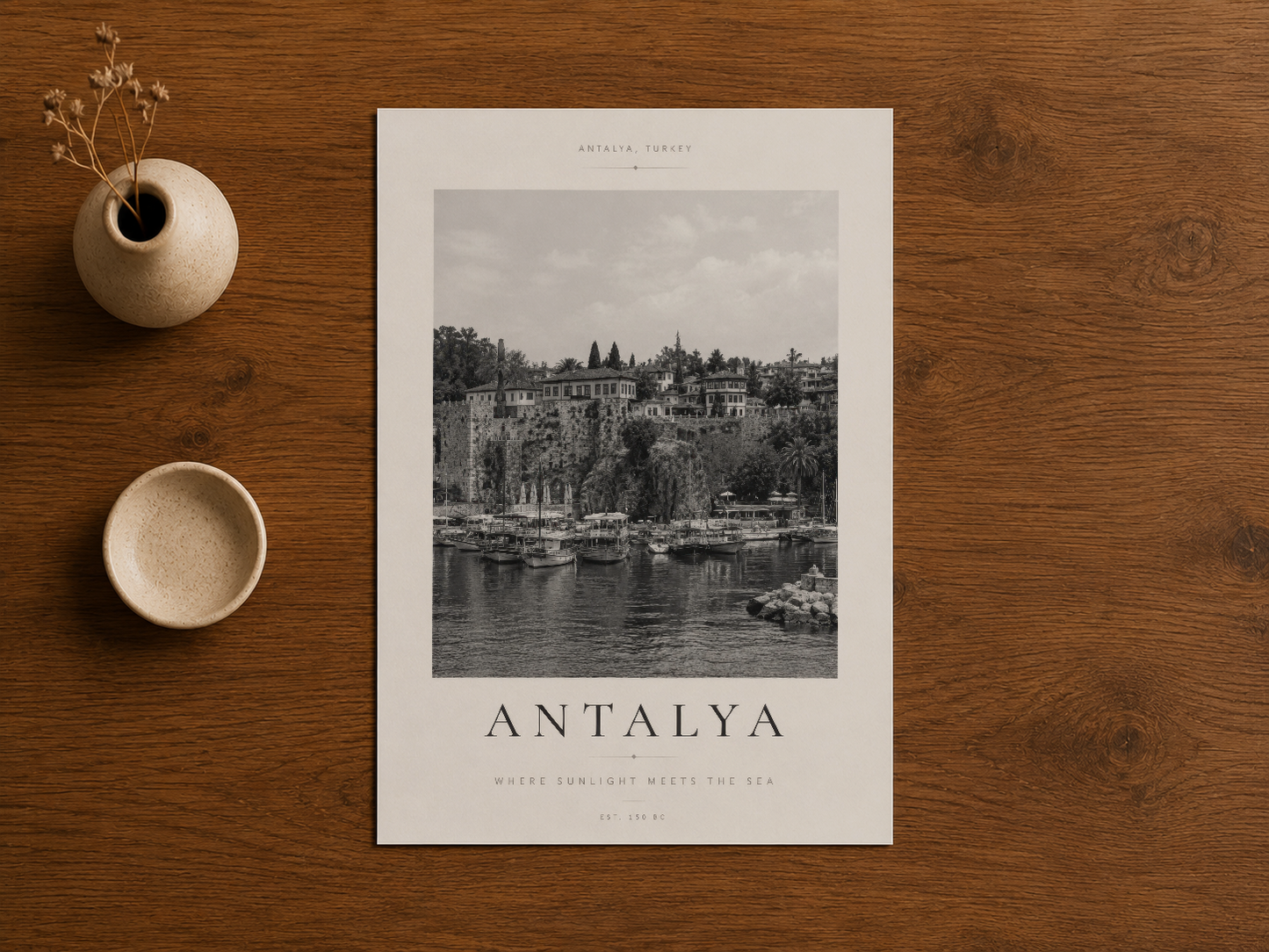 Antalya manzarası tablosunun ahşap masada, seramik aksesuarların yanında sergilenmiş temiz görünümü.