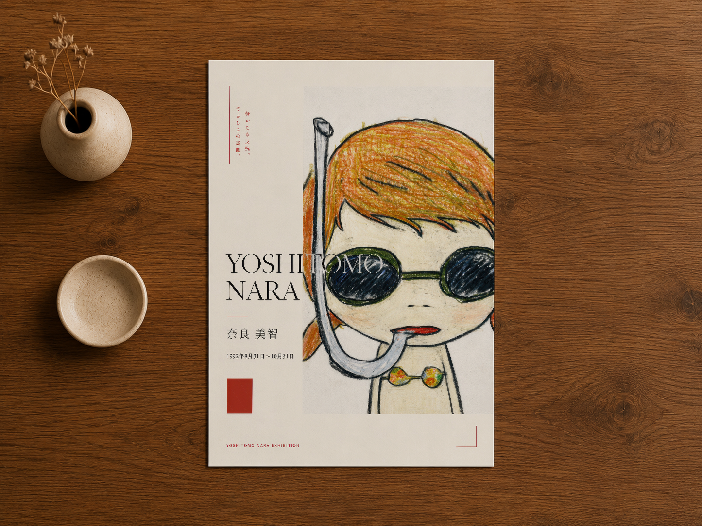 Ahşap masa üzerinde sergilenen Yoshitomo Nara karakteri baskısı, minimalist tasarım detayları.