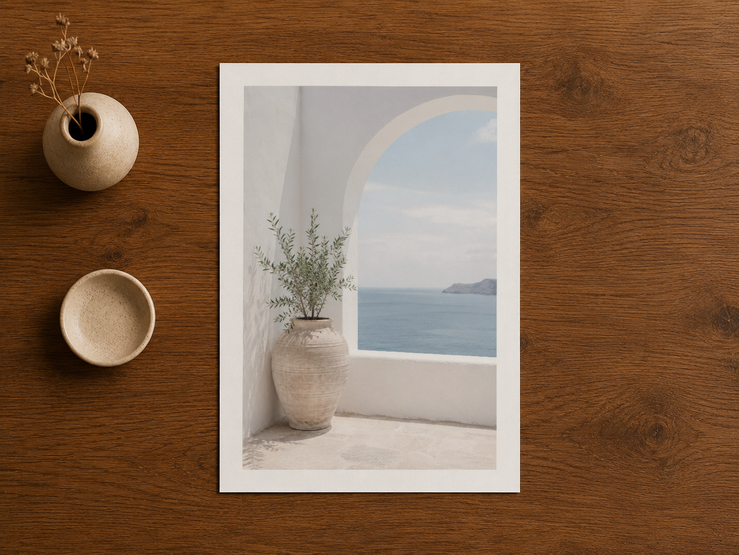 Doğal ahşap arka plana karşı çerçeveli sanat baskısı, pastel deniz manzarası ve minimal dekoratif estetik.