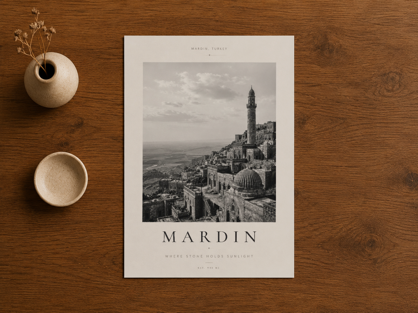 Mardin'in İslami mimarisini konu alan siyah-beyaz duvar posteri, ahşap masa üstünde.