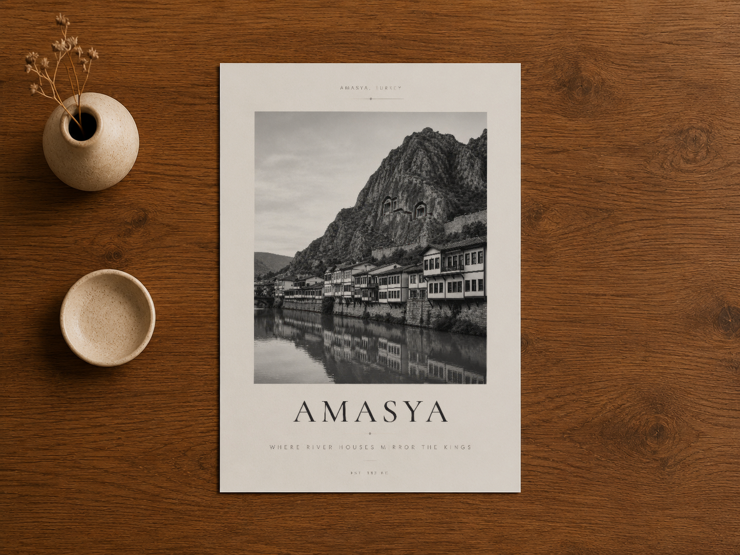 Ahşap masa üzerinde seramik aksesuar yanında duran Amasya poster, Türk sanat ve seyahat tasarımının zarif ifadesi.