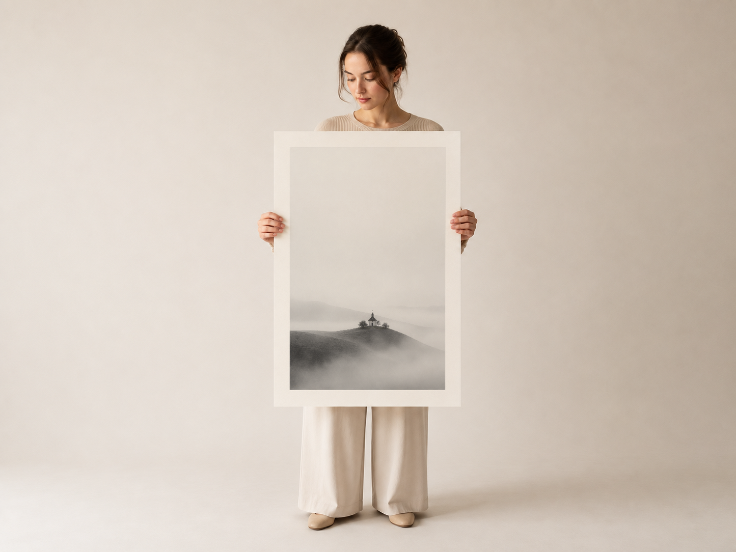 Minimalist beyaz çerçeveli, atmosferik sisli manzara motifli sanat tablosunu gösteren model fotoğrafı.