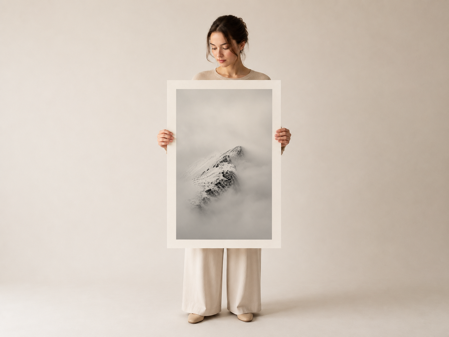 Çerçeveli kar dağı sanat eserini sunan kadın, minimalist ve poetic doğa fotoğrafının güzelliğini vurgulayan.