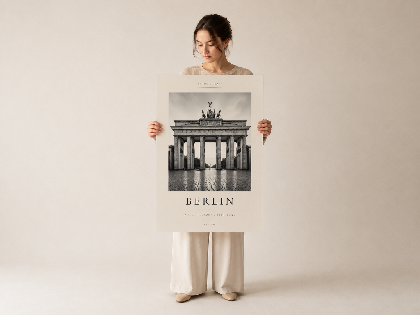 Bayan tarafından tutularak sergilenen Berlin duvar tablosu, temiz tasarım ve profesyonel baskı kalitesini vurgulayan poster.