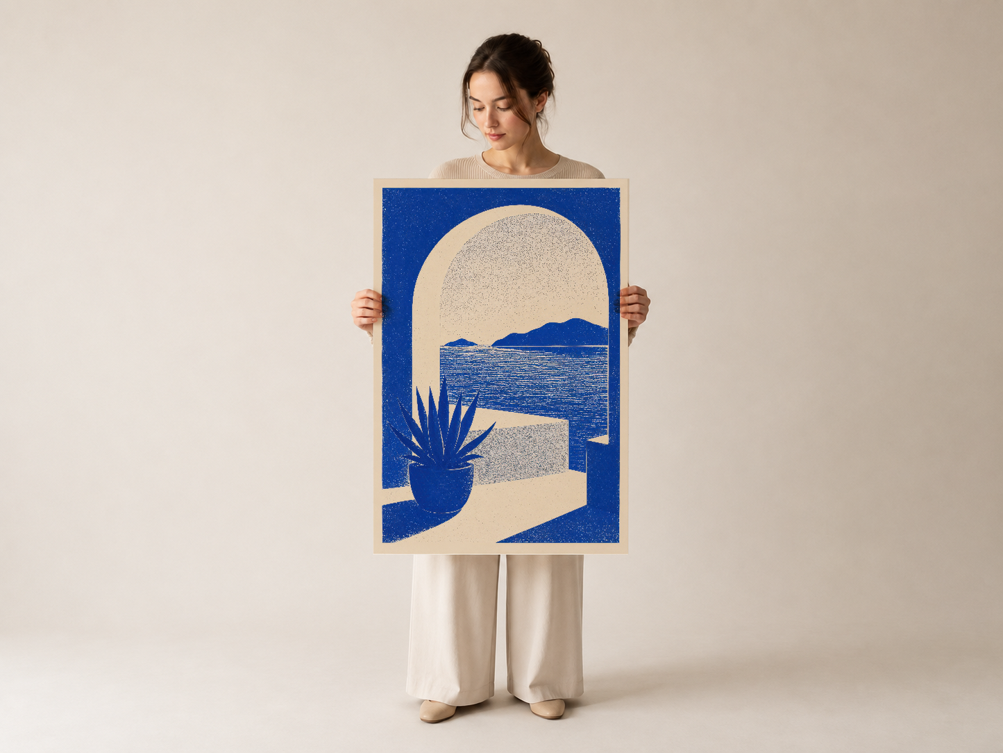 Kadın tarafından sergilenen sanatsal mavi poster, deniz manzarası ve agave bitkisi silueti tasarımı içeriyor.