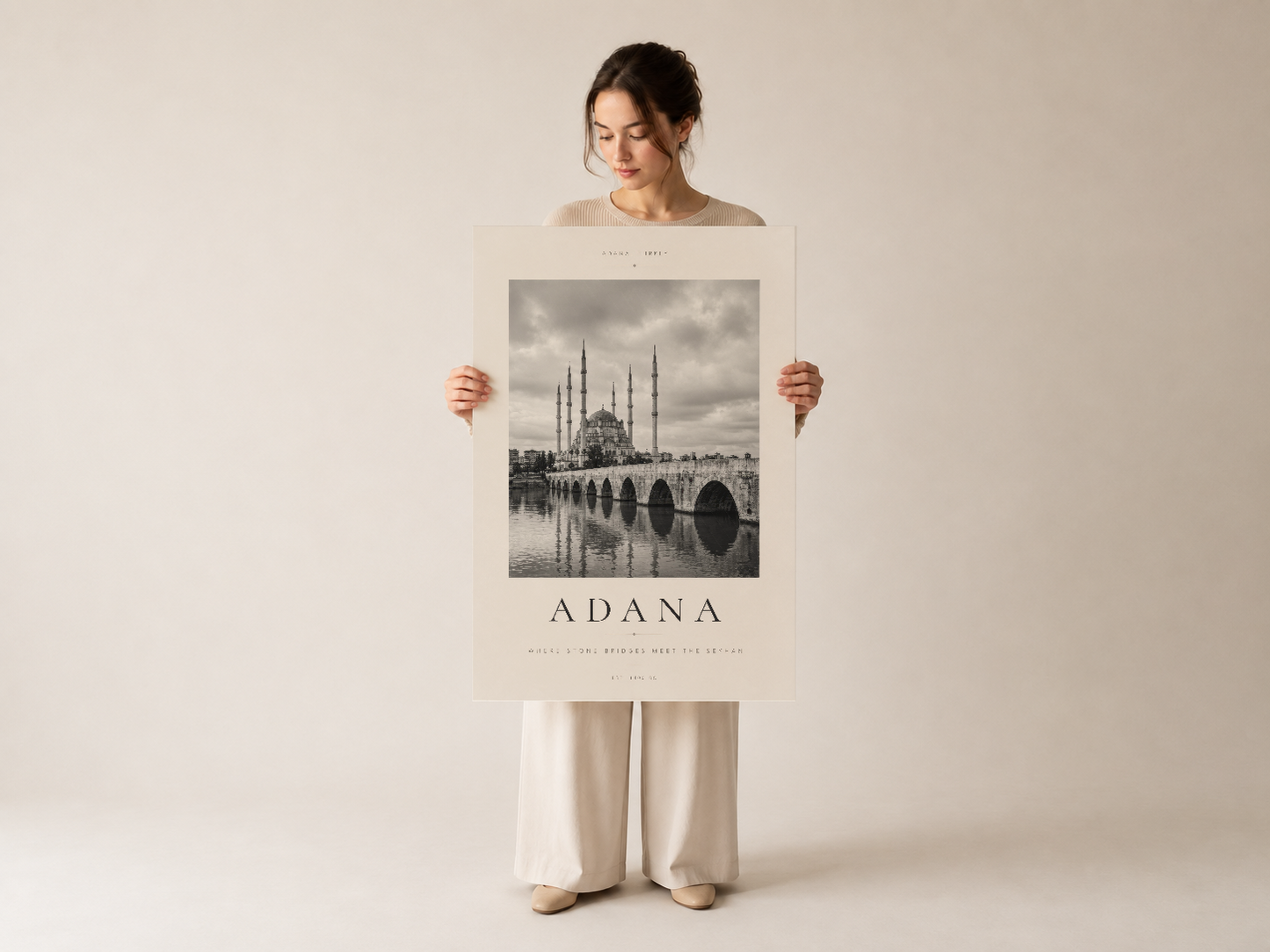 Adana travel poster, siyah-beyaz mimari detaylı baskısı el tarafından tutulmuş, nötr arka planda.