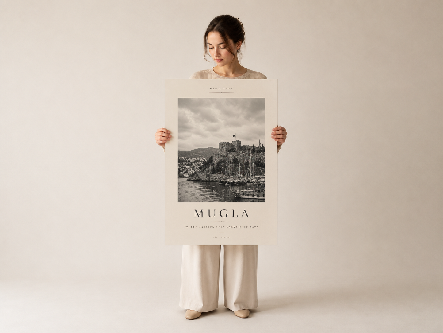 Muğla kalesinin minimalist siyah beyaz sanat posterini elinde tutan, nötr arka fondaki kişi tarafından sunulan baskı.
