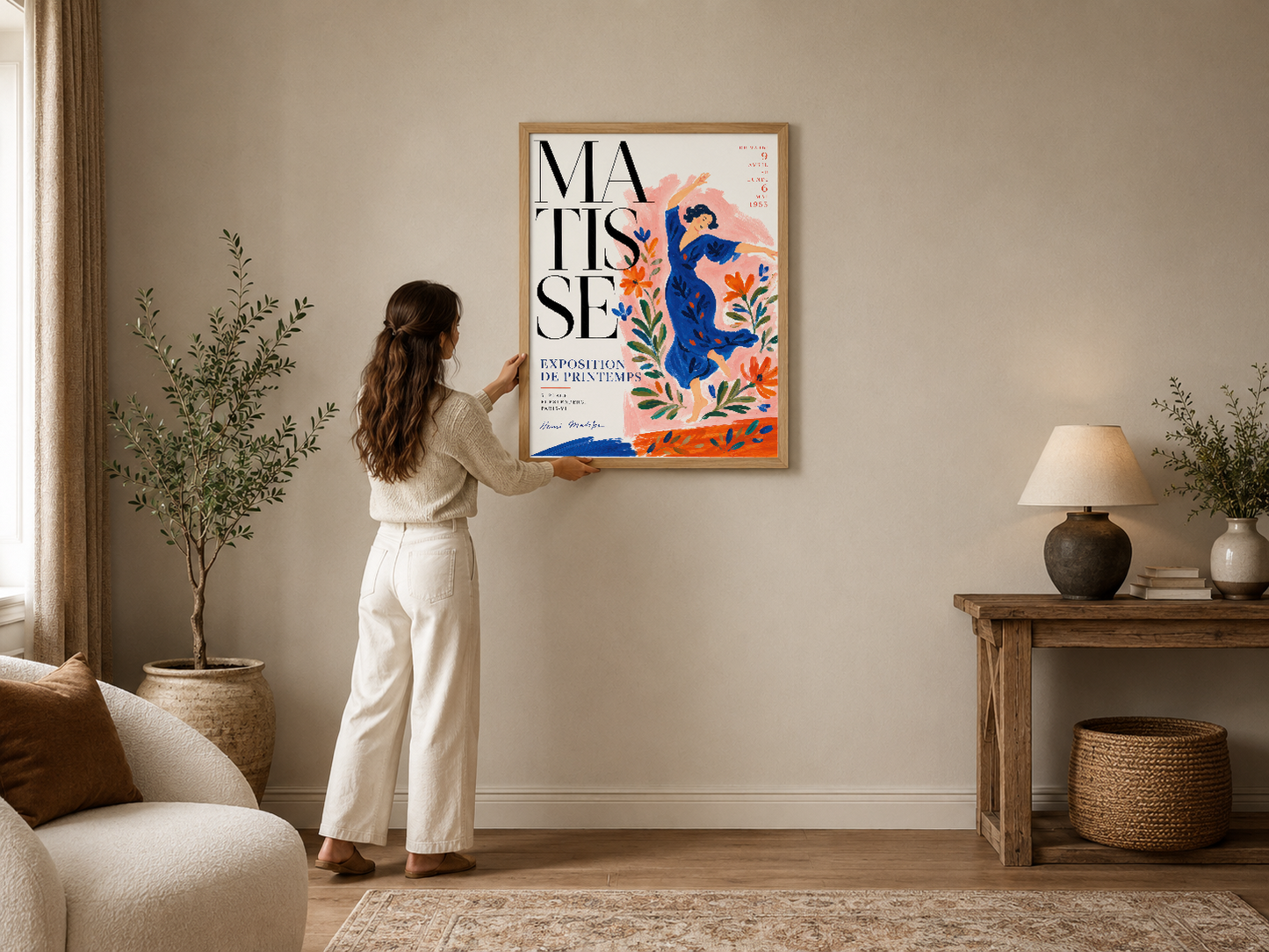 Matisse esintili sanat sergisi posteri, soyut mavi figür ve turuncu çiçeklerle modern bir oturma odasını canlandırıyor.