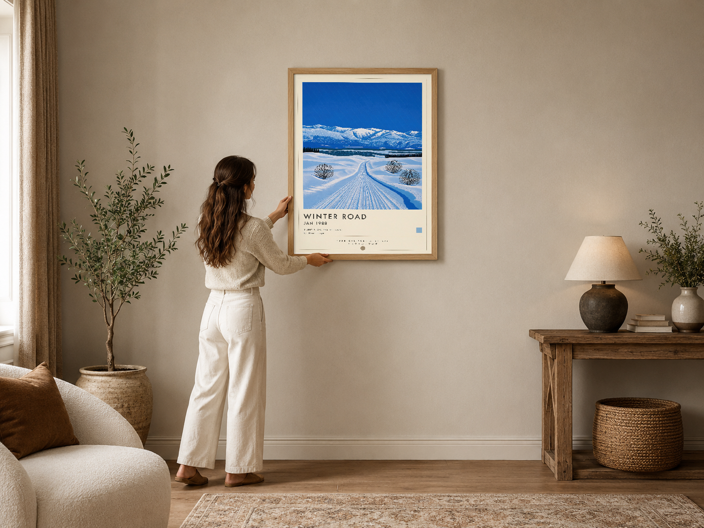 Çerçeveli Winter Road posteri, beyaz ve bej tonlarındaki modern oturma odasında kanepenin üzerinde sergileniyor.