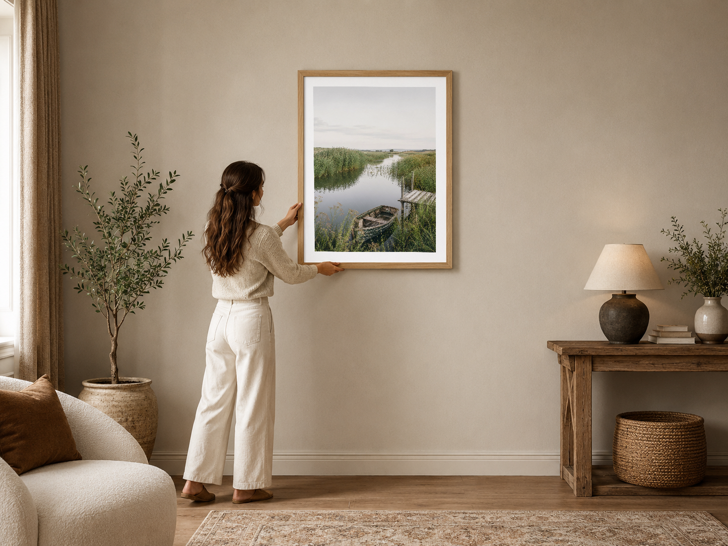 Doğal ahşap çerçeveli sakin göl manzarası tablosu, modern beige oturma odasının dekorasyonunu tamamlıyor.