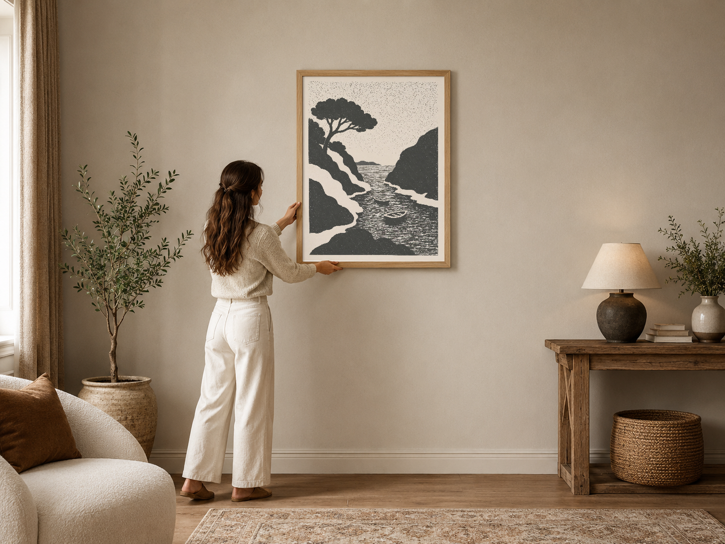 Doğal ışık alan nötr oturma odasında çerçeveli, siyah beyaz deniz manzaralı ağaç tasarımlı modern poster.