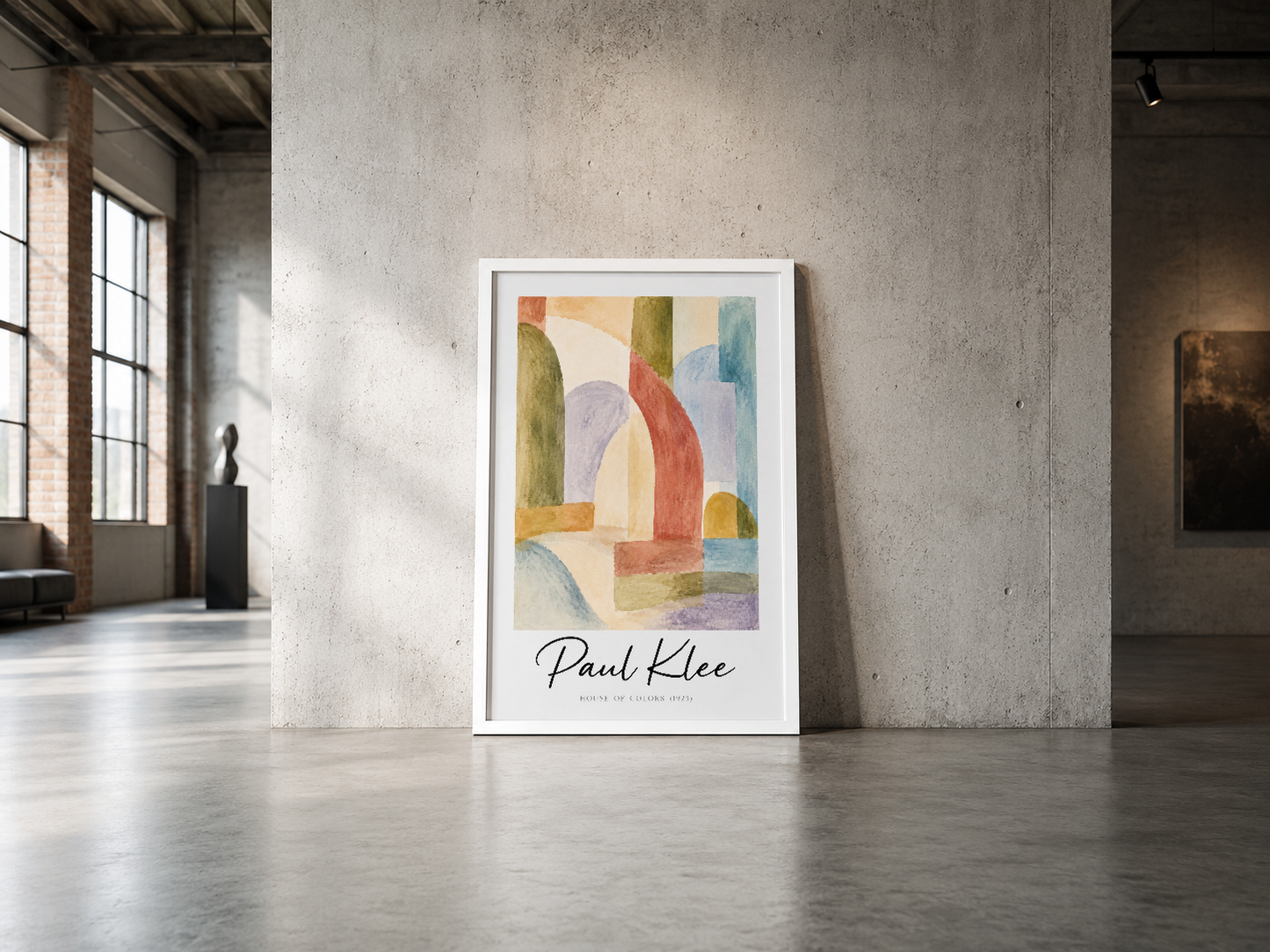 Paul Klee Renkli Evler baskısı, beyaz çerçeveli, endüstriyel beton duvara dayandırılmış konumsallaştırma.