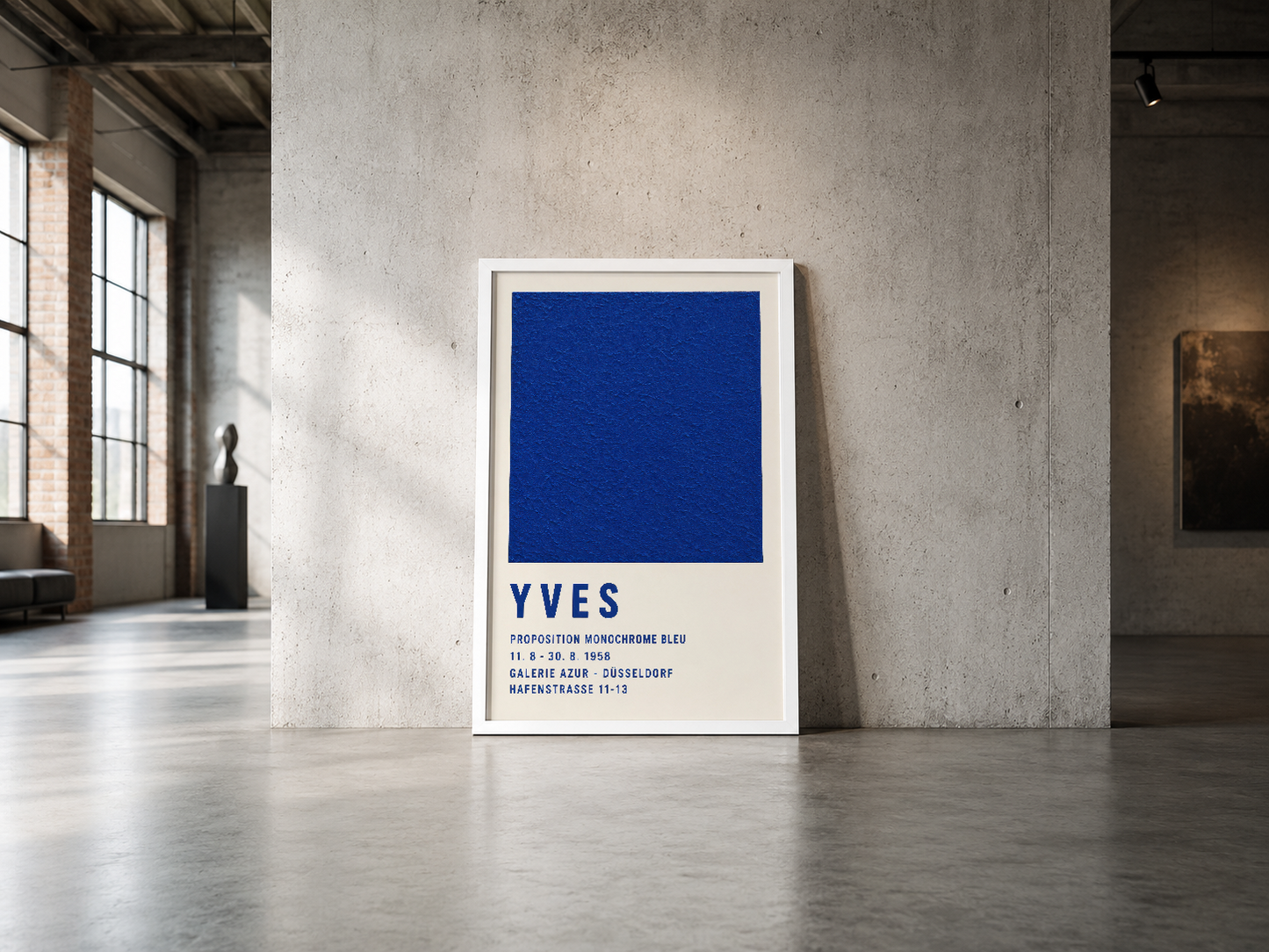 Endüstriyel betonlu galeri duvarında sergilenen, beyaz çerçeveli Yves monokrom mavi sanat tablosu.