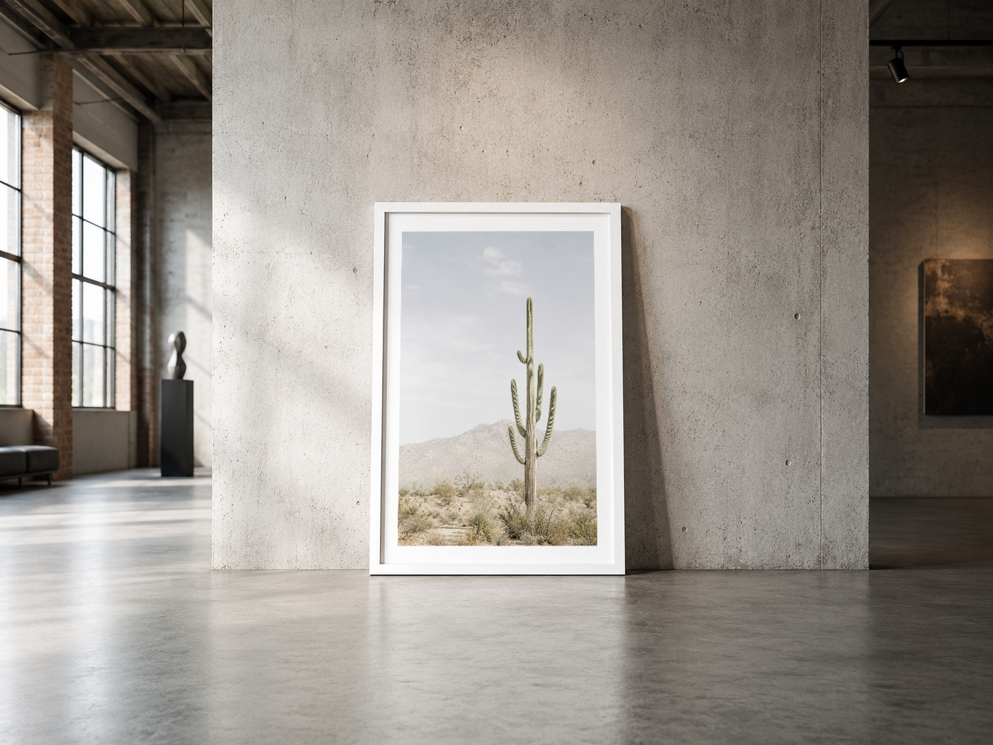 Beyaz çerçeveli kaktüs posteri, endüstriyel beton duvarda duran minimalist çöl fotoğrafı.