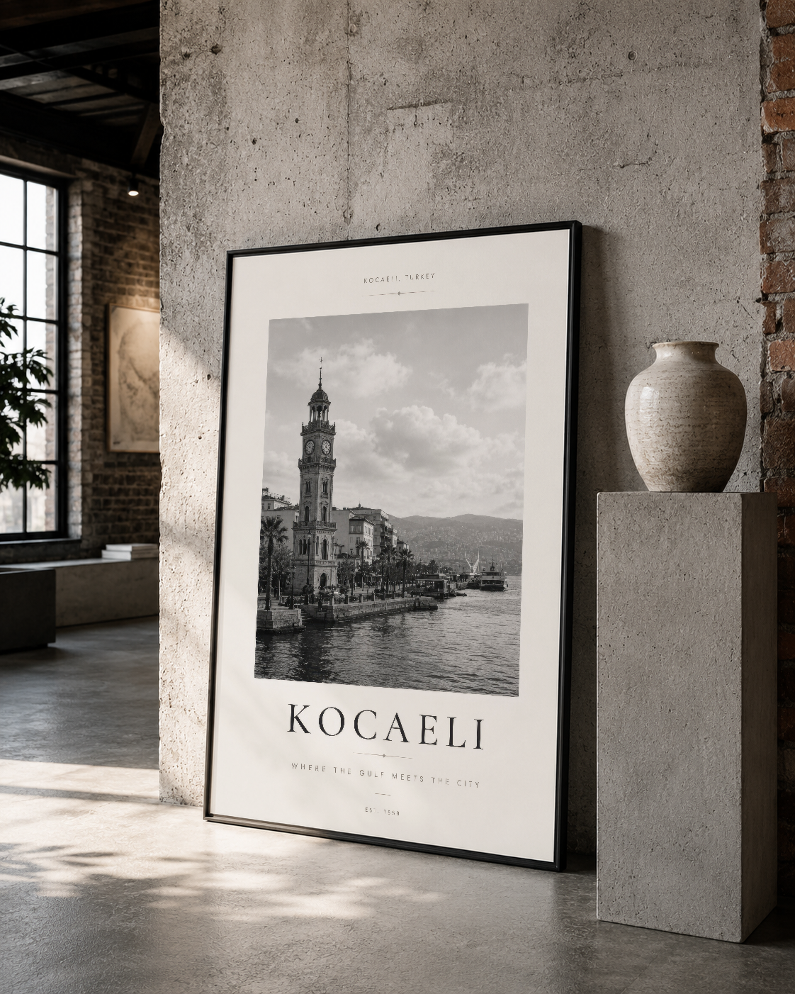 Saat kulesinin yer aldığı İzmit körfezi manzarası, siyah çerçeveli poster, beton duvarda minimalist dekorasyon içinde.