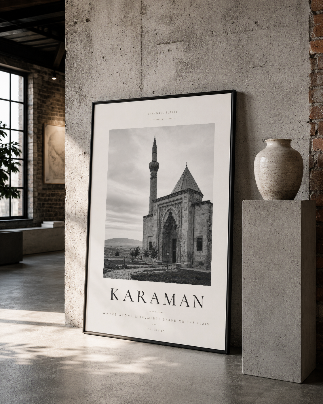 Siyah çerçeveli Karaman Camii posteri, beton duvarın yanında endüstriyel loft dekorasyonunun merkezinde yer alan sanat eseri.