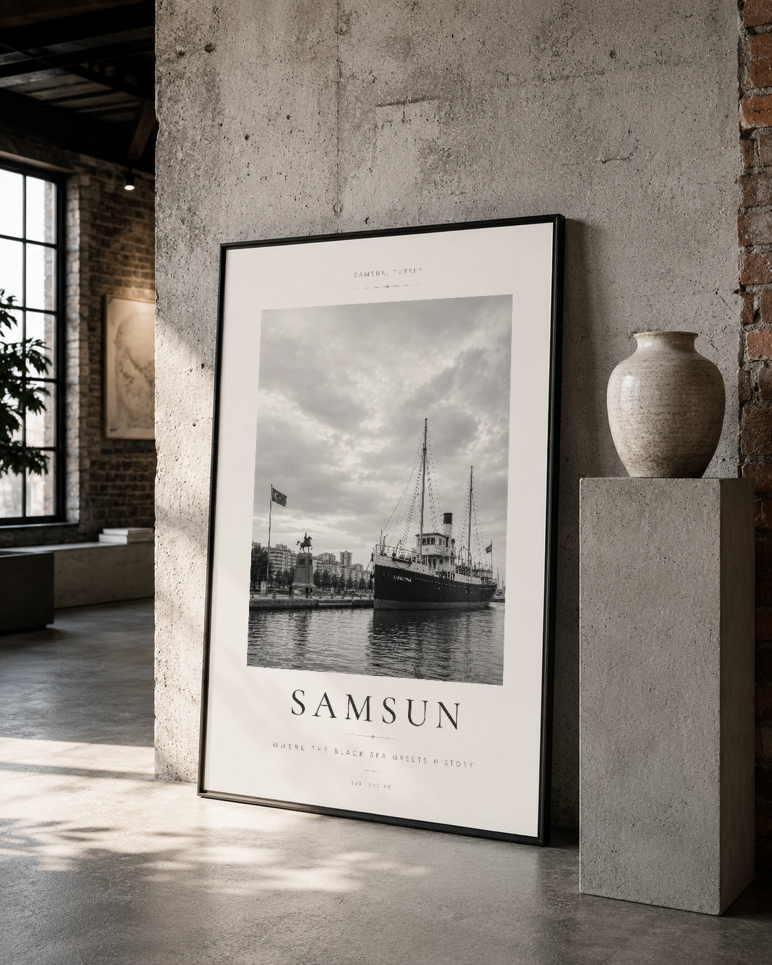 Samsun rıhtımının retro tarzı siyah çerçeveli tablosu, pürüzlü duvar ve seramik vazo ile rustik iç mekan tasarımında.