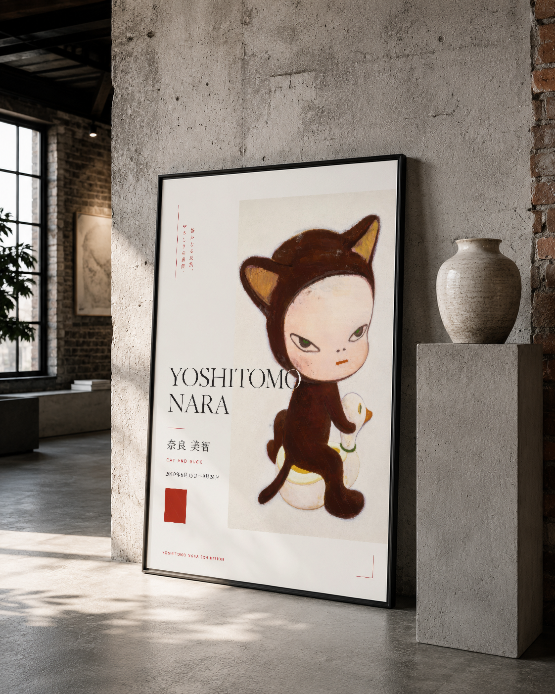 Yoshitomo Nara imzalı kedi karakterli poster, siyah çerçevede rustik mekanda sanatsal atmosfer.